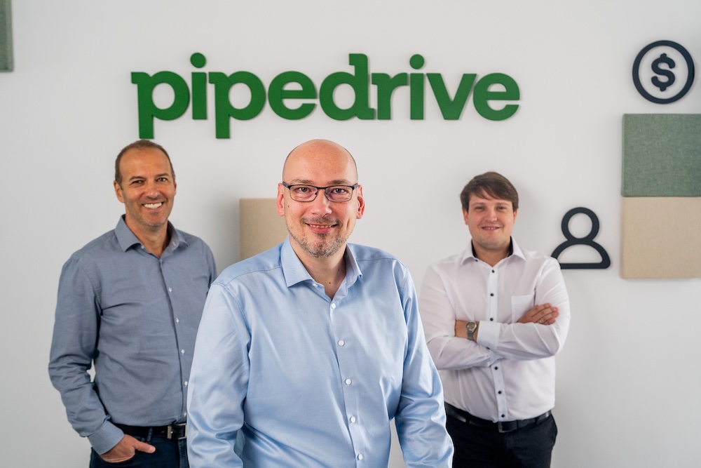 A Sales & Workflow csapatának három tagja a Pipedrive-logó előtt
